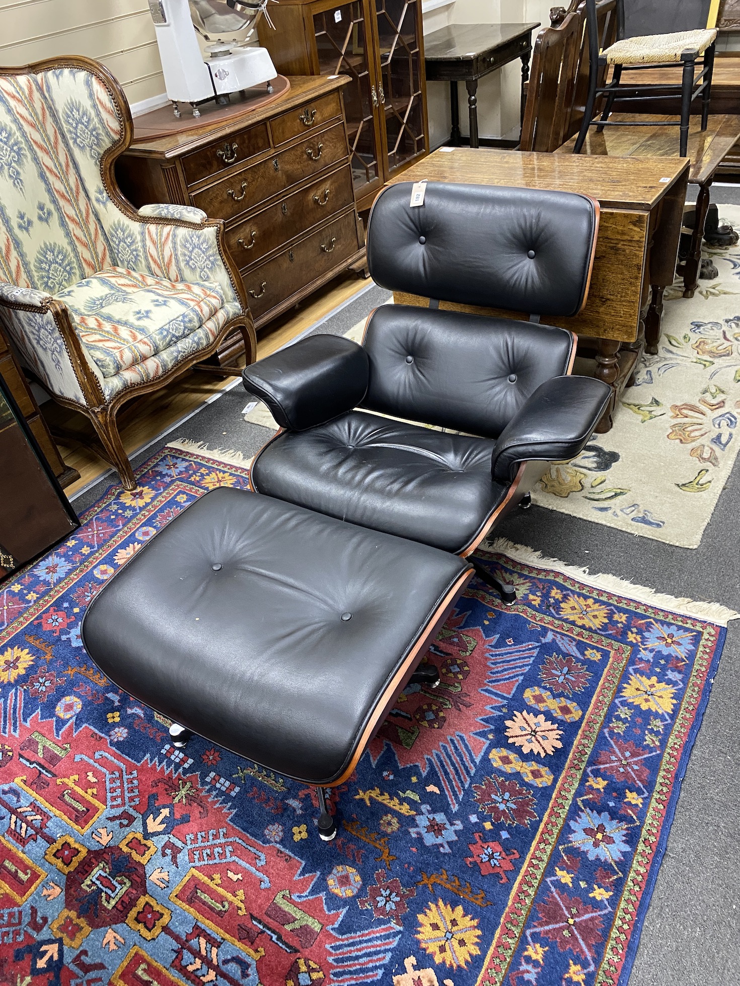 An Eames style recliner armchair and footstool